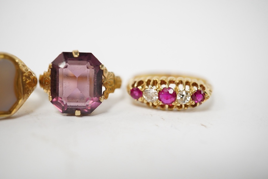 A group of four rings, comprising: a chalcedony signet ring with engraved floral shoulders, size L, partial British hallmarks for 15ct gold; a synthetic ruby and diamond five-stone ring, size N, stamped 18CT; a ring set